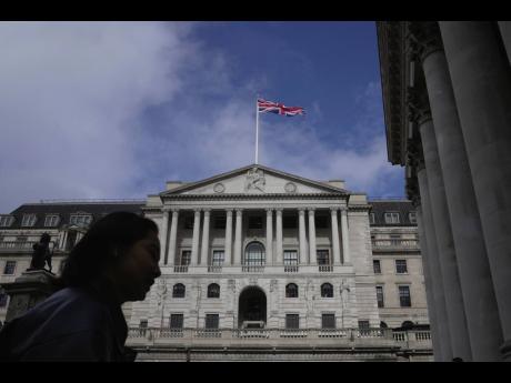 A woman walks in front of the Bank of England in the financial district in London on Thursday, March 23, 2023.