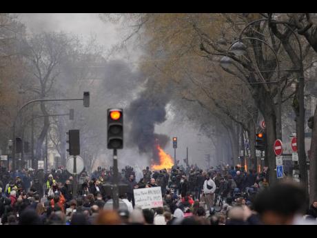 Protesters gather next to a burning barricade during a rally in Paris yesterday.