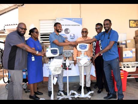 Junior Resident at the Black River Hospital (BRH), Dr Richard Johnson (3rd left) accepts the donation from Project C.U.R.E from senior medical officer at the BRH, Dr Sheriff Imoru (right). Also in photo are: Consultant Paediatrician for the BRH, Dr Aggrey 