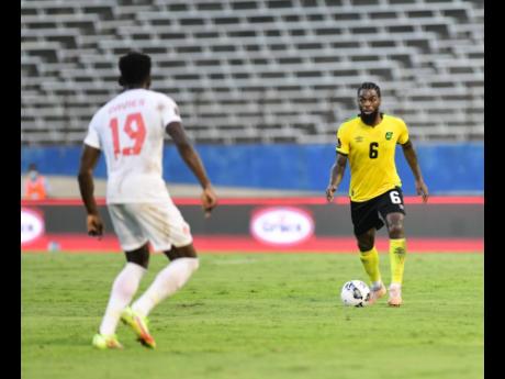 Jamaica’s Anthony Grant (right) in action against Alphonso Davies of Canada at the National Stadium in 2021.