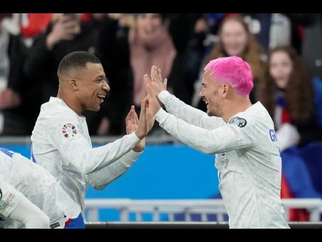 France’s Antoine Griezmann (right) celebrates with France’s Kylian Mbappe after scoring his side’s opening goal during the Euro 2024 Group B qualifying match between France and the Netherlands at the Stade de France in Saint Denis, outside Paris, Fra