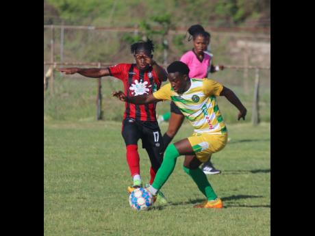 Arnett Garden's Romeo Guthrie (left) tries to rob the ball from Vere United's Fakibi Farquharson during their Jamaica Premier League (JPL) encounter at the Wembley Centre of Excellence yesterday. The match drew 1-1.