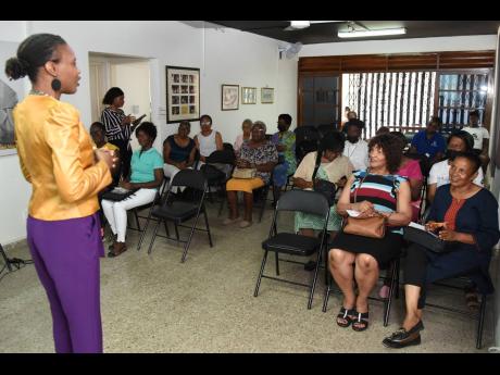 Shelly-Ann Thompson (left), founder and principal director, Golden Designs Limited, talks with senior citizens during a cybersecurity awareness seminar at the Manley Centre in St Andrew on Saturday.
