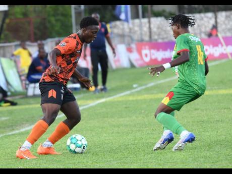 Christopher Matthews (left) of Tivoli Gardens prepares to go past Javon Smith of Humble Lion during last night’s Jamaica Premier League match at the Anthony Spaulding Sports Complex. Humble Lion won 2-1.