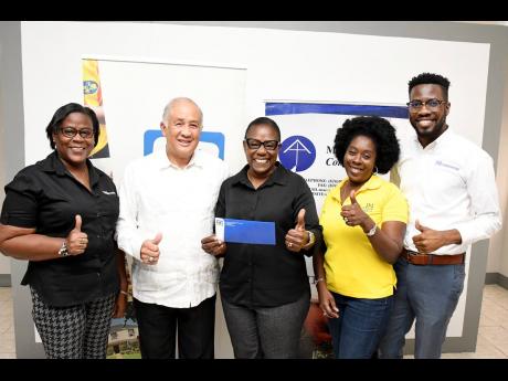 Darcy Tulloch-Williams (centre), executive director of the Mustard Seed Communities in Jamaica, shows her appreciation for the funds received from Parris Lyew-Ayee(second left), chairman of the JN Foundation and other members of the JN Foundation team. Amo