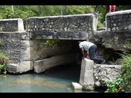 Persons examine cracks and wear in the structure of the 114-year-old Grossmond Bridge.