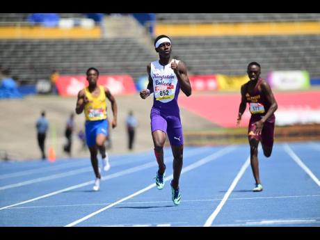 Kingston College's Taj-Marques White is the picture of composure as he completes a semi-final win in the Boys' Class II 400 metres at the ISSA/GraceKennedy Boys and Girls' Athletics Championships on at the National Stadium. Following him to the line are St