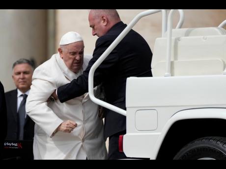 Pope Francis helped to get in his car at the end of weekly general audience in St Peter’s Square, at the Vatican yesterday.
