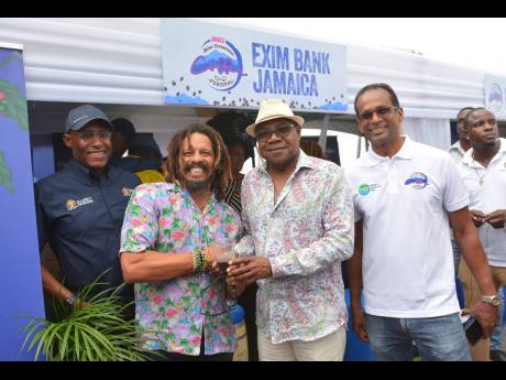 Tourism Minister Edmund Bartlett (second right); Minister of Industry, Commerce and Investment, Senator Aubyn Hill (left); and Executive Director of the Tourism Enhancement Fund, Dr Carey Wallace (right), share lens time with Marley Coffee proprietor Rohan