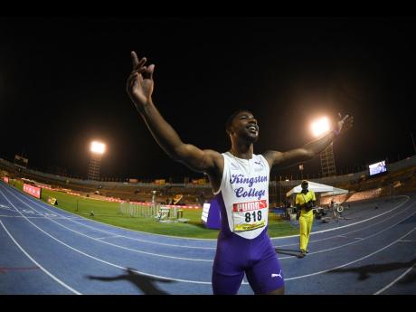 Kingston College captain Bouwahjgie Nkrumie raises his hands skyward after blitzing his opponents and the clock in the Class I 100 metres at the ISSA/GraceKennedy Boys and Girls’ Athletics Championships inside the National Stadium last night. 