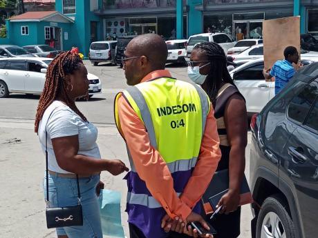 Director of INDECOM, Errol Chattoo (centre), speaking with Michelle Samuels (left), sister of Avado Samuels, the man who was allegedly shot and killed by the police in Mount Pleasant on Sunday morning.
