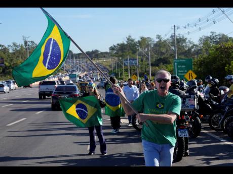 Supporters wait for the arrival of Brazil’s Former President Jair Bolsonaro outside the Brasilia International Airport, in Brasilia, Brazil, yesterday.
