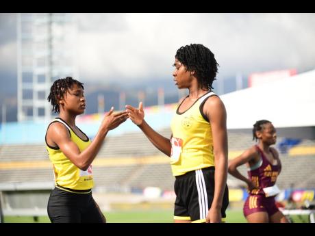 Alikay Reynolds (right) of Alphansus Davis High celebrates her gold medal in the Class Three 1500 metres with teammate and bronze medalist Tabbrel Williams at the National Stadium on Wednesday.