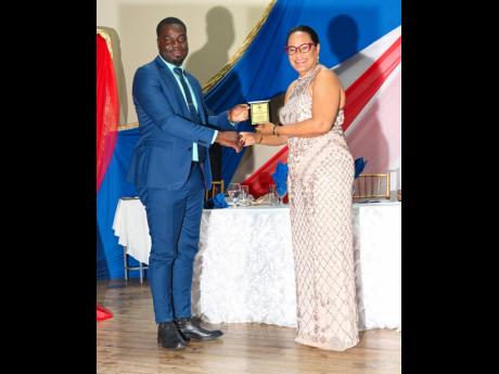 Detective Corporal Omardo Heaven accepts his 2022 award from Sophia Loraine-Perrin, wife of Hartley Perrin, custos of Westmoreland. Heaven received the award in recognition of his work which saw him amassing the highest number of arrests across the Westmor