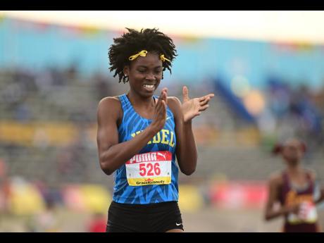 Hydel High’s Oneika McAnnuff celebrates gold in the 400 metres  hurdles open final at the ISSA-GraceKennedy Boys and Girls’ Championships at the National Stadium last night.  McAnnuff won in 56.46 seconds. 
