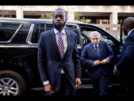 Prakazrel ‘Pras’ Michel, a member of the 1990s hip-hop group the Fugees, accompanied by defense lawyer David Kenner, arrives at federal court for his trial in an alleged campaign finance conspiracy, last Thursday in Washington.
