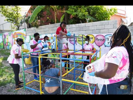 Volunteers from Hospiten Jamaica and other team members from the Montego Bay Chamber of Commerce and Industry, Janet Richards Foundation, parents and members from the Mt. Salem Community Development Committee are captured here painting the monkey bar in th
