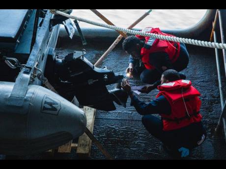 US Navy Machinist’s Mate 3rd Class Kasine Kerr (right) and Machinist’s Mate 3rd Class Craig Lee perform maintenance on a rigid hull inflatable boat aboard the aircraft carrier USS Nimitz (CVN 68). Nimitz is in the 7th fleet conducting routine operation