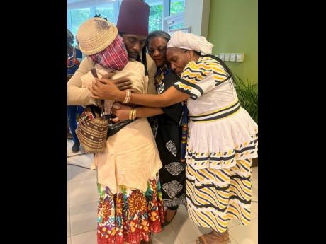 Members of the Garifuna delegation from Belize, Gloria Simms (left), Nana Marguerite (second right), and Cynthia Lubafu, embrace Accompong Maroon chief Richard Currie.