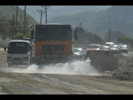 A plume of dust covered the 8 Miles, Bull Bay community on Thursday as a water truck sprinkled the road with water in an attempt to reduce the dust nuisance.