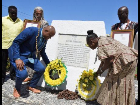 Port Maria Mayor Richard Creary and Culture Minister Olivia Grange lay wreaths at the Tacky monument in Port Maria during the civic ceremony to commemorate National Chief Takyi Day on Saturday. Looking on are (from left) Robert Montaque; Dr Vincent Brown; 