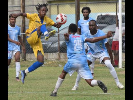Shamaro Dennis (left) of Molynes United goes high to control the ball in front of Tevin Thompson (centre), Kyle Anderson (right) and Joel Powell (second right) of Faulkland FC during their Jamaica Premier League football match at the Waterhouse mini stadiu