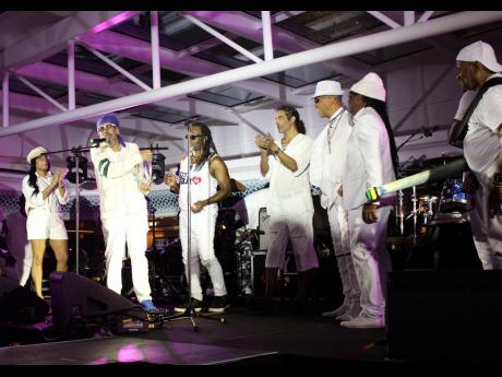 Members of Third World band show their appreciation after they are honoured on stage the Love and Harmony Cruise by Ronnie Tomlinson, public relations and communications manager, who presented them with a plaque from the organisers in recognition of their 