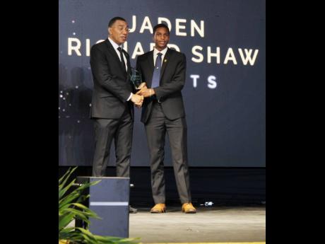 Jaden Shaw of Wolmer’s Boys’ School accepts the Prime Minister’s National Youth Award for Excellence in Sports from PM Holness, on the lawns of Jamaica House recently.