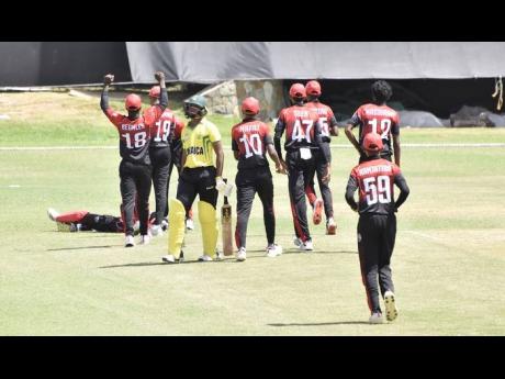 Trinidad and Tobago players (red and black) celebrate the loss of a Jamaican wicket during their West Indies Rising Stars under-15 Championship game at the Coolidge Cricket Ground on Monday. 
