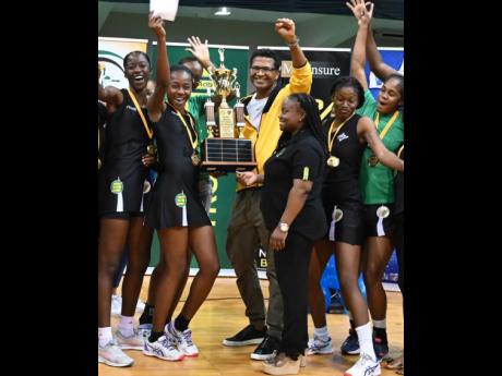 Manchester Spurs captain Shanice Beckford (second left) collects the winners’ trophy from Netball Jamaica President Tricia  Robinson at the National Arena  last night. Spurs defeated St Ann Orchids 2-0 in the best of three finals of the Seprod Netball Ja