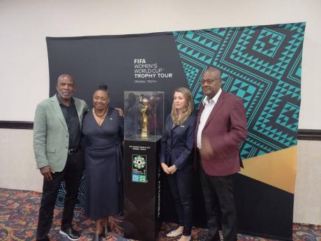 From left: National senior womens head coach, Lorne Donaldson, Sports Minister Olivia Grange, Sarah Gandoin, FIFA representative, and Michael Ricketts, JFF president, pose with the FIFA Women's World Cup trophy during a tour at the Jamaica Pegasus Hotel 