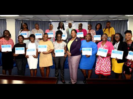 La Sonja Harrison (5th right) president, Jamaica Teachers Association (JTA), stands with recipients of the JTA’s Inaugural Basic School Teritiary Education Grant Awards during the presentation ceremony at the JTA’s Head Office in Kingston on Friday.