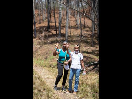 Cynthia Williams (right), tour guide, and Denise Yorke, trekker, celebrate arriving at the four-kilometre mark of the hike at Forest Trek on March 25.