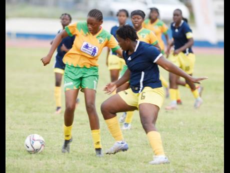 Britannia McDonald (right) of  Garvey Maceo High tackles Jada-Lee Bryan of  Excelsior High during the ISSA Tip Friendly schoolgirls football semi-final played at the Ashenheim Stadium, Jamaica College yesterday. Excelsior won 1-0. 