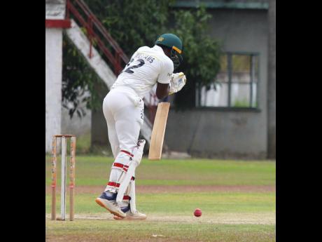 
St Catherine CC opener Oraine Williams plays defensively during the first day of Senior Cup action against St Elizabeth at Chedwin Park yesterday. Williams ended the day 38 not out after his medium pace brought him figures of 3-15. 