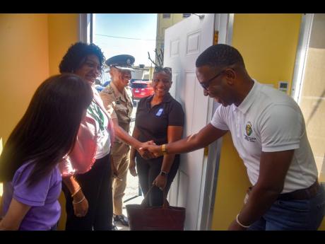 Detective Corporal Damion Hammond (right) invites (from left) Linda Maguire, deputy director, UNDP in Latin America and the Caribbean; DSP Jacqueline Dillon, head of the Domestic Violence Intervention Centres (DVIC);  Senior Superintendent Christopher Phil