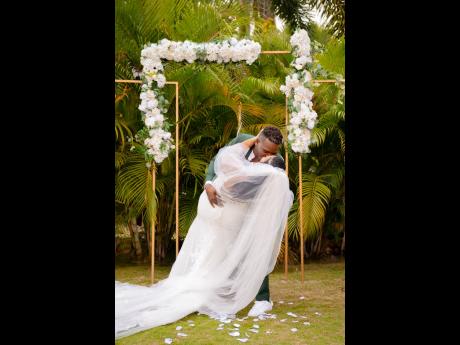 A man with a flair for romance, Kemoi Burke sweeps Melanie Fitz-Henley Burke off her feet as he plants the kiss that seals the deal in making her his wife. 