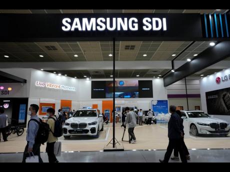 In this June 9, 2021 photo, people walk by Samsung SDI Company’ booth during the InterBattery 2021 trade show, the country’s leading battery exhibition, at COEX in Seoul, South Korea.