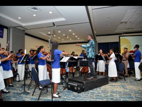 Steven Woodham conducts the Immaculate Conception High School Symphony Orchestra at The Distinguished awards at the Pegasus last Monday. 