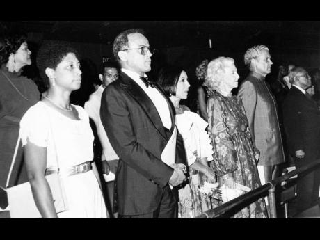 In this July 10, 1982 photo, a section of the audience stands in salute at the playing of the National Anthem. In front row from left are Beverley Manley; Harry Belafonte, guest speaker; Mrs. Belafonte; Edna Manley; and Michael Manley, son of National Hero