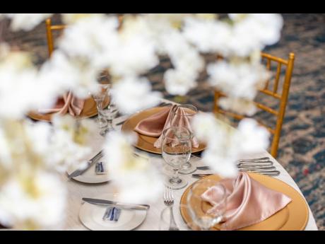A peek through the cherry blossoms reveals the elegant table setting with gold chargers. 