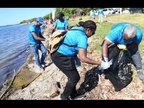From left: Sanjah Brevett; Nia Souden, business development officer at CG United Insurance; Winsome Gibbs, country manager of CG United Insurance; and Andre Higgins; IT specialist at CG United Insurance, picking up garbage during the Earth Day beach clean-