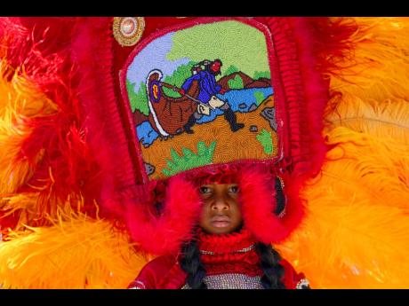 A young member of the Golden Comanche Mardi Gras Indians parades through the New Orleans Jazz & Heritage Festival.
