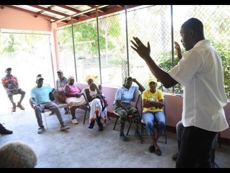 Patricia Garrick (centre) and other members of the Kanga Gully Farmers Group listen as Danavan Pryce, agronomist at Newport-Fersan (Jamaica) Limited, explains the proper way to use fertilisers during last Tuesday’s session.