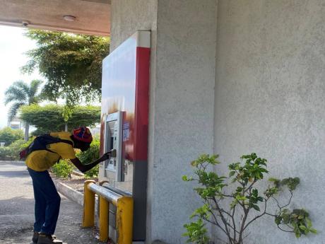 Sean Ramsay tries to get cash at a drive-thru ATM in Portmore, St Catherine, on Monday morning after unsuccessfully trying several other locations to get cash to pay his fare to work.