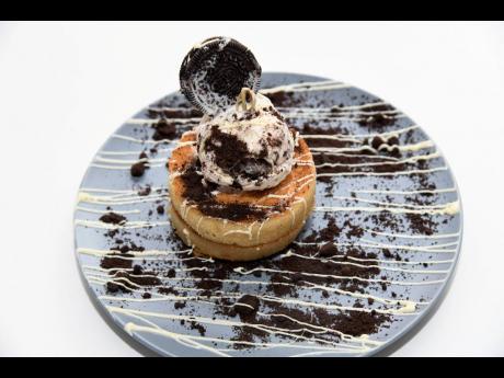 The cookies and dreams are pancakes served with crushed oreos and cookies and cream ice cream and a white chocolate sauce.