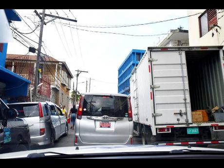 Delivery trucks and transport operators reduce Market Street in Montego Bay to single lane traffic
