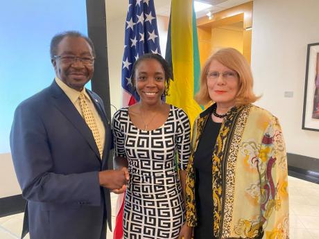 United States Ambassador Nick Perry (left) shakes hands with Javanna Campbell, recipient of a grant from The American Friends of Jamaica (AFJ) Inc, at the grants ceremony held at the United States Embassy in St Andrew on Tuesday. Sharing in the moment is D