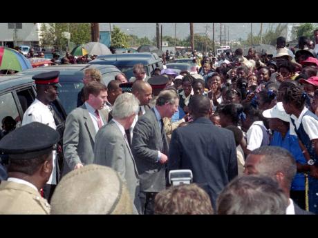 Charles, Prince of Wales, is greeted by a throng of residents from Trench Town as he arrives at the Trench Town Culture Yard and Village on Tuesday, February 29, 2000.