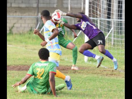 Waterhouse goalkeepe Kemar Foster (right), dives to his right to parry a shot from  Humble Lion’s Karim Bryan (left) during their Jamaica Premier League football match at the Waterhouse Mini Stadium yesterday. The match ended 0-0.